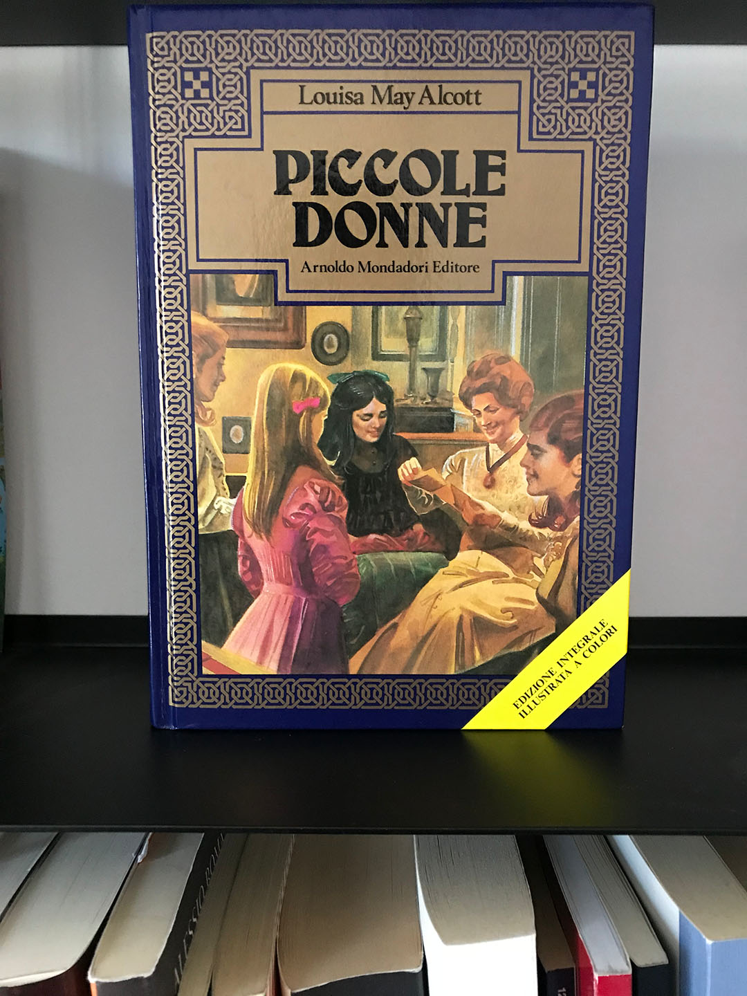Copertina del romanzo Piccole donne di Louisa may alcott con le sorelle march raccolte intorno alla madre.