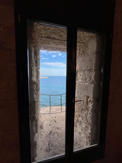 finestra nella pietra che affaccia sul mare blu